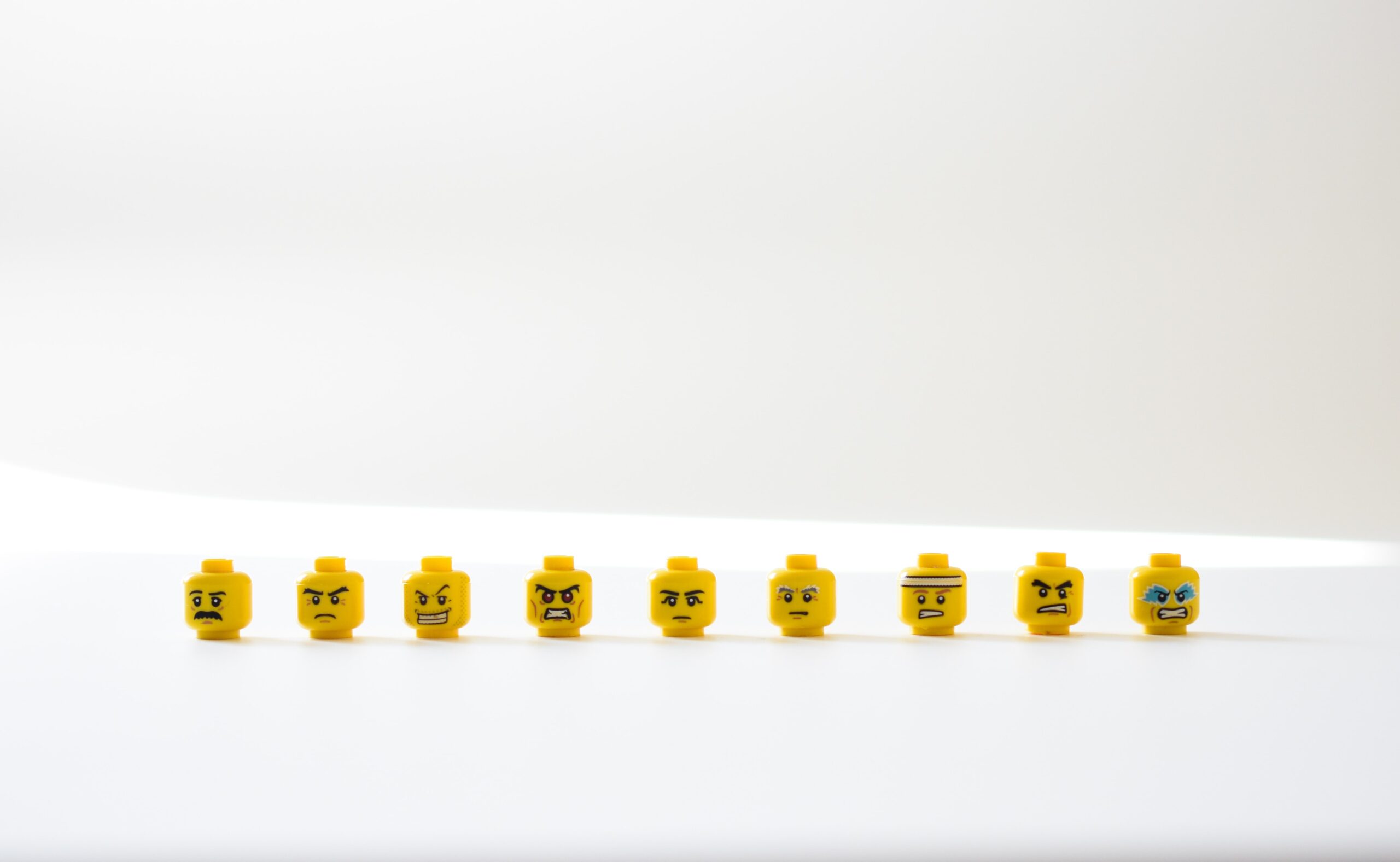 Row of unhappy lego faces representing negative feedback. Image by Nik on Unsplash.
