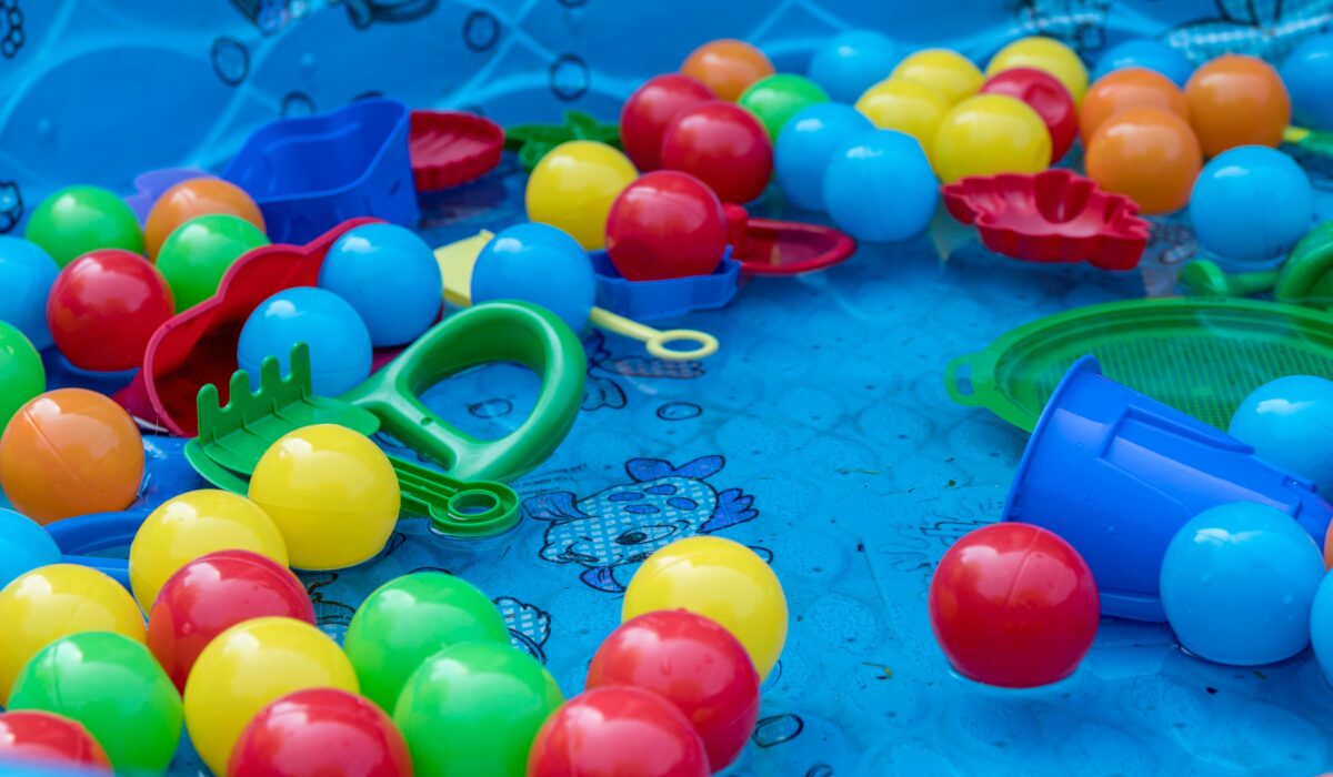 Ball-pit balls and toy spades lie in an paddling-pool with nobody playing in it, representing the perk-cession. Image by Christine Tutenjian on Unsplash. Thanks Christine.
